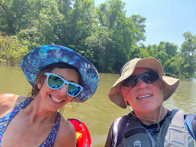 Janice Sitzes, director of Continuing and Professional Education in the College of Natural Resources, and her boyfriend smile for a picture as they paddle kayak adventure down a river trail.