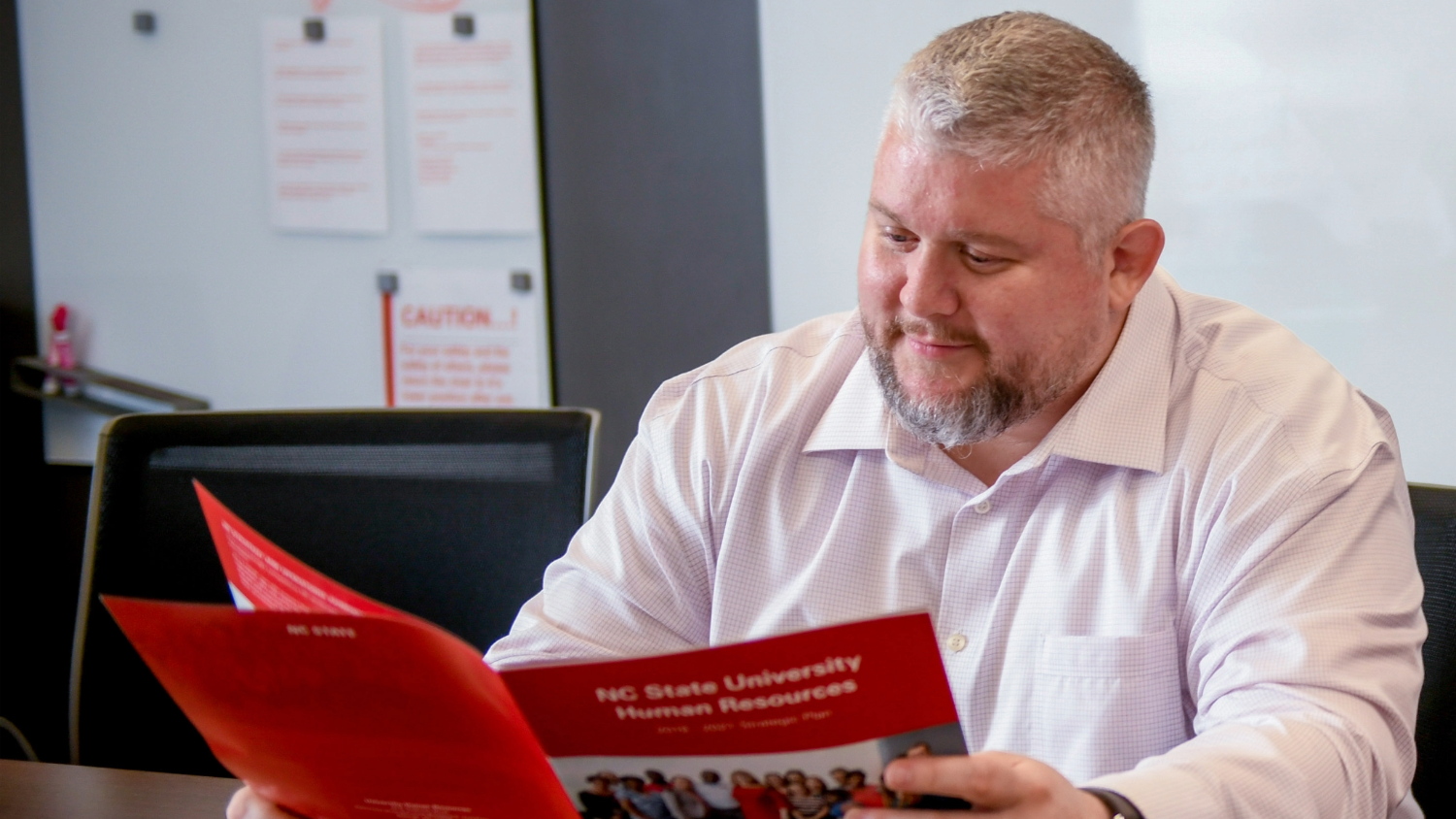 A photo of Ryan Bernarduci looking at an HR annual report.