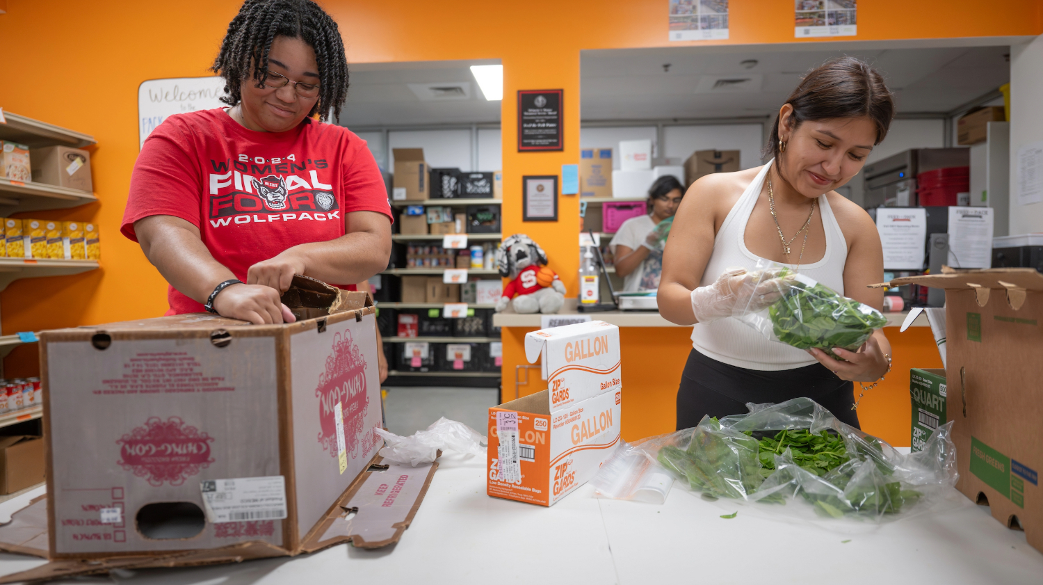 Two students work at Feed the Pack food pantry.